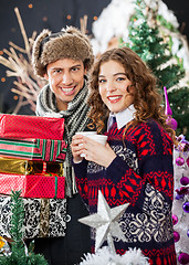 Image showing Young Couple With Disposable Cups And Christmas Presents