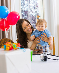 Image showing Mother Holding Boy With Messy Hands Covered With Cake Icing