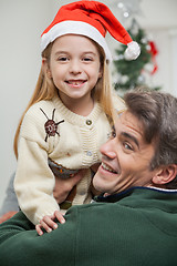 Image showing Girl In Santa Hat Being Carried By Father