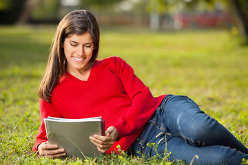 Image showing Student Reading Book While Relaxing At College Campus