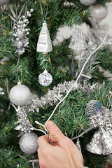 Image showing Man Decorating Christmas Tree With Fairy Lights