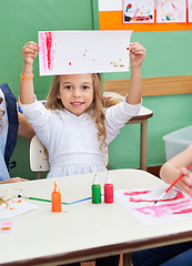 Image showing Girl Showing Painting At Classroom Desk