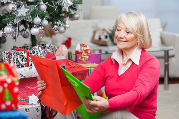 Image showing Smiling Senior Woman Choosing Bags