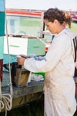 Image showing Beekeeper Fueling Smoker For Removing Honey