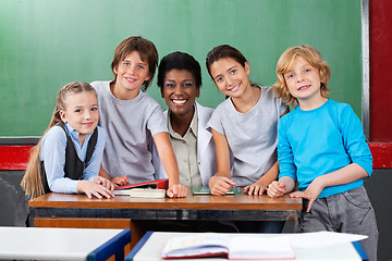 Image showing Teacher With Schoolchildren At Desk In Classroom