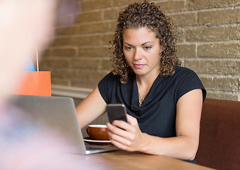 Image showing Woman Texting in Cafe