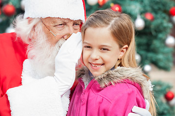 Image showing Santa Claus Whispering In Happy Girl's Ear