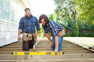 Image showing Construction Workers Looking At Spirit Level On Plank