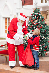 Image showing Santa Claus Giving Present To Boy