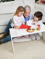 Image showing Man Assisting Children In Making Christmas Greeting Card