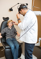 Image showing Optician Examining Boy's Eye Through Lens