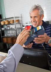 Image showing Customer Paying Through Mobile Phone In Store