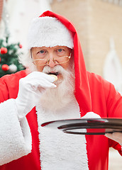 Image showing Santa Claus Eating Cookies Outdoors