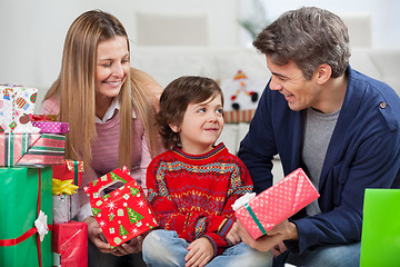 Image showing Parents With Christmas Presents Looking At Son