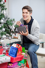 Image showing Happy Man With Gifts Sitting By Christmas Tree