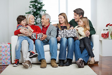 Image showing Family With Christmas Presents Sitting On Sofa