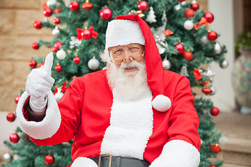 Image showing Santa Claus Gesturing Thumbsup Against Christmas Tree