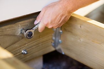 Image showing Carpenter's Hand Tightening Bolt With Wrench