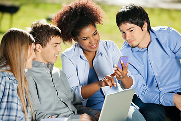 Image showing Student Using Mobilephone While Classmates Looking At It