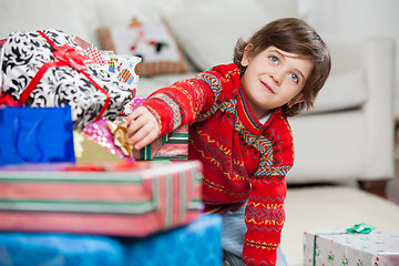 Image showing Boy Taking Christmas Gift From Stack