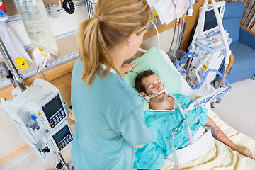 Image showing Nurse Adjusting Young Patient's Pillow In Hospital