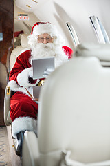 Image showing Santa Using Tablet Computer In Private Jet