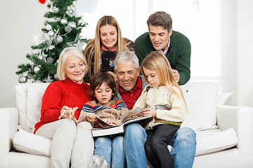 Image showing Family Reading Book Together In House