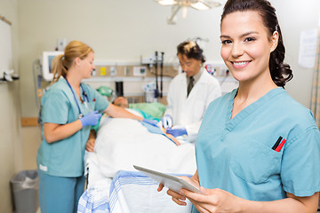 Image showing Nurse With Digital Tablet While Doctor And Colleague Operating P