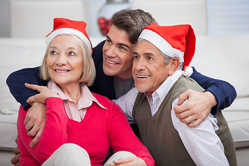 Image showing Loving Son With Parents Wearing Santa Hats