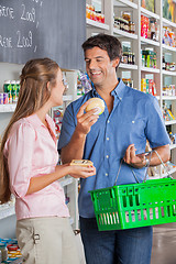 Image showing Couple Comparing Cheese At Grocery Store