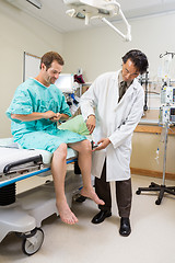 Image showing Doctor Examining Patient's Knee With Hammer In Hospital