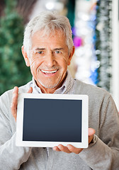 Image showing Happy Man Displaying Digital Tablet In Christmas Store