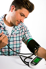 Image showing Man taking his blood pressure reading.