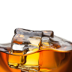 Image showing Close up splash of whiskey with ice isolated on white