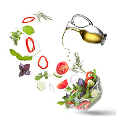 Image showing Falling vegetables for salad and oil isolated