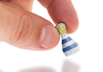 Image showing Hand holding wooden pawn, flag painting, selective focus