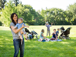 Image showing Happy Mother Carrying Baby Boy At Park