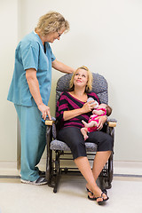 Image showing Mother Feeding Milk To Newborn Babygirl While Looking At Nurse