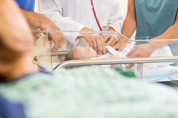 Image showing Doctor Examining Baby While Standing By Nurse