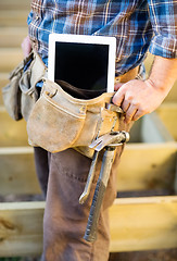 Image showing Midsection Of Carpenter With Tablet Computer And Hammer In Toolb