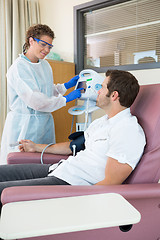 Image showing Nurse Looking At Patient While Operating Heartbeat Monitor In Ho