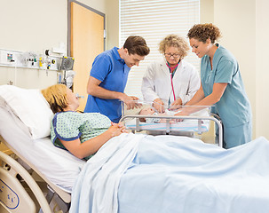 Image showing Doctor Examining Babygirl While Parents And Nurse Looking At Her