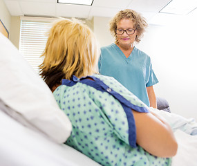 Image showing Nurse Looking At Newborn Babygirl With Mother In Hospital