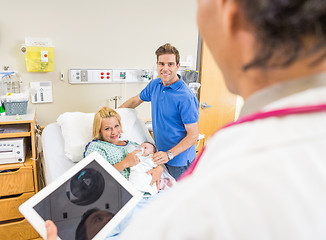 Image showing Couple With Babygirl Looking At Doctor Holding Digital Tablet