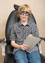 Image showing Boy With Trial Frame Holding Test Chart At Optician