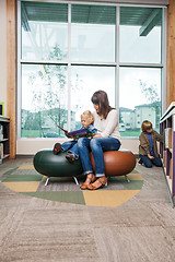 Image showing Boy With Teacher Reading Book In Library