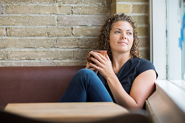 Image showing Thoughtful Woman Holding Coffee Mug In Cafe