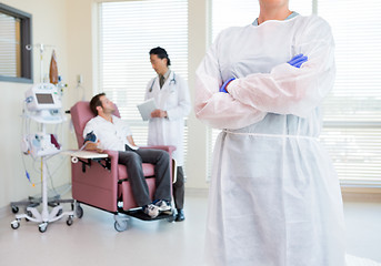 Image showing Nurse Standing Arms Crossed While Doctor Examining Patient's Hea