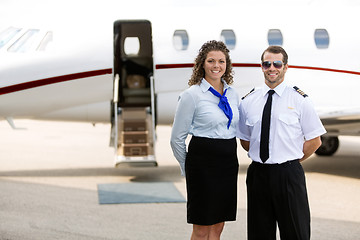 Image showing Airhostess And Pilot Standing Against Private Jet