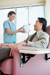 Image showing Nurse Looking At Patient While Operating IV Machine